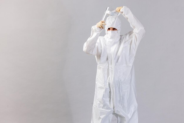 Tired doctor wearing mask and gloves at the hospital in coronavirus times checking his smartphone