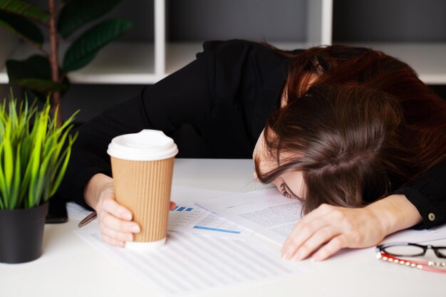 Tired employee working at desk at company office.