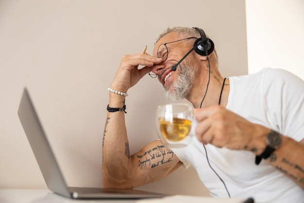 Усталый предприниматель потирая нос после работы с ноутбуком