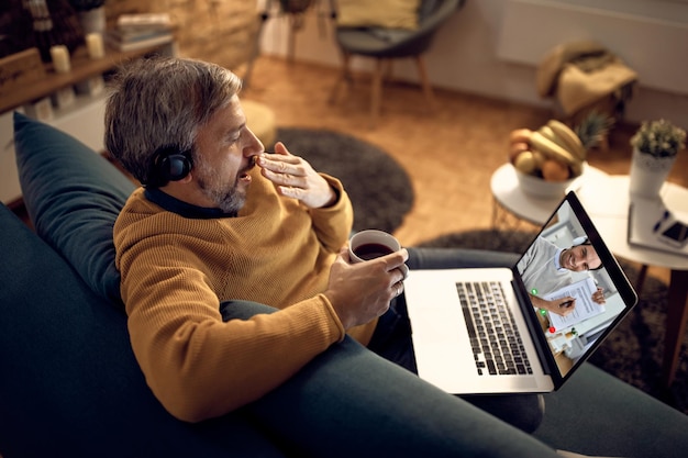 Tired entrepreneur yawning during conference call at night