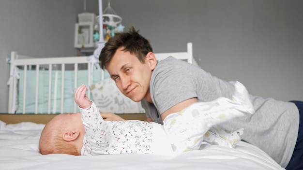 Tired father sits near newborn girl waiting baby calms down