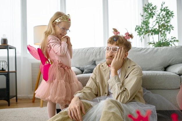 Tired father wearing having fun with daughter