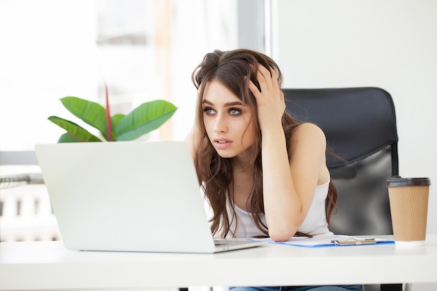 Tired female working a laptop computer in office