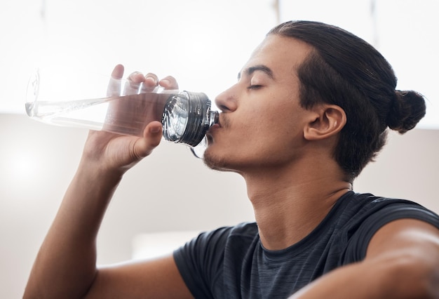 Photo tired fitness or man drinking water in gym for fitness training or health workout exercise relax sports or wellness athlete with water bottle for hydration sport thirst or rest in studio