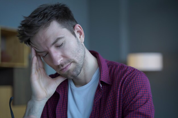 Photo tired freelancer man sitting at home office working remotely online suffering from headache