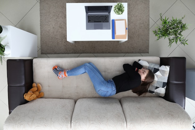 Tired from work girl sleeps at home on couch