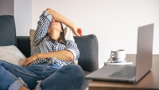 Tired from work young woman in front of a laptop