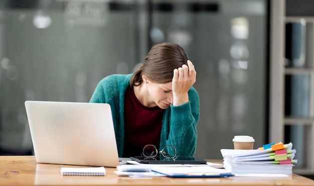 Donna stanca e frustrata che si sente stressata, che tiene la testa e che si preoccupa del fallimento degli affari.