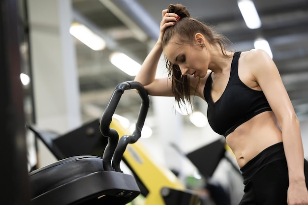 Foto ragazza stanca che riposa in palestra