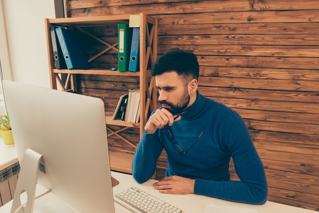 Uomo bello stanco che ha una dura giornata in ufficio