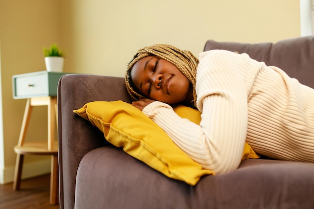 Tired latin hispanic woman taking nap on the sofa during the day