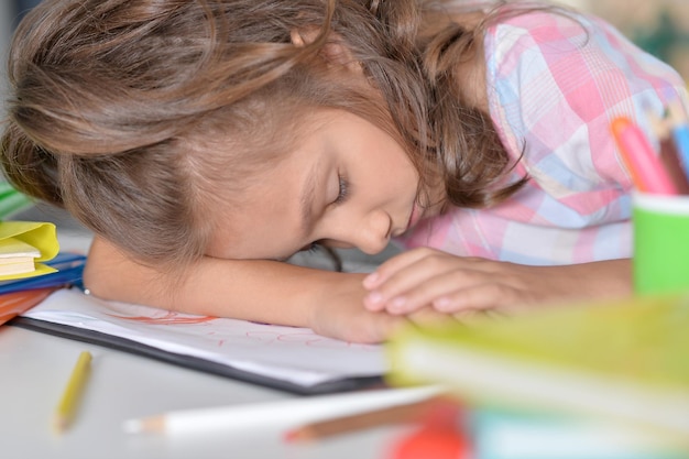 Tired  little girl sleeping on her drawings