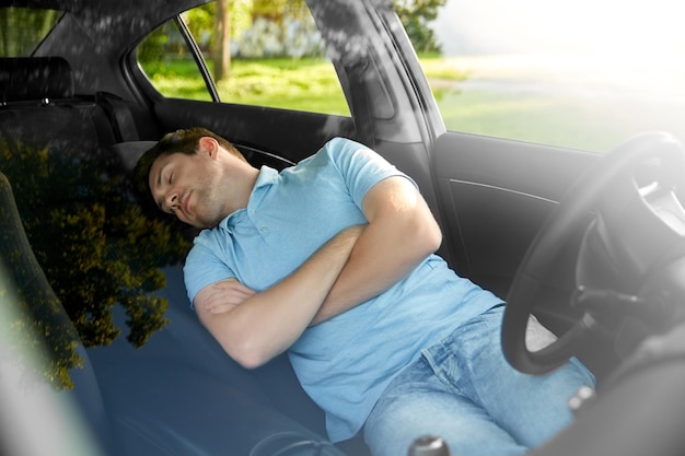 疲れた男性や運転手が車の中で眠っている