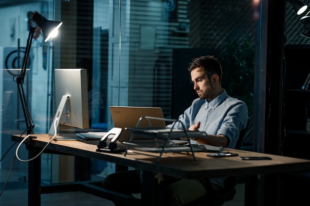 Tired man at laptop in office