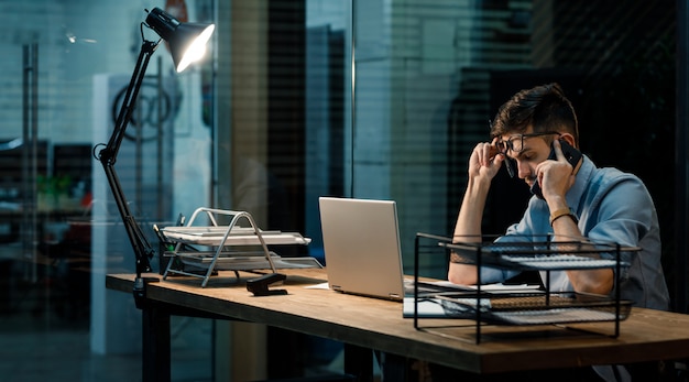 Tired man in office with laptop