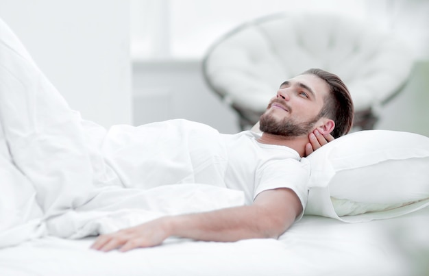 Tired man resting on a comfortable bed