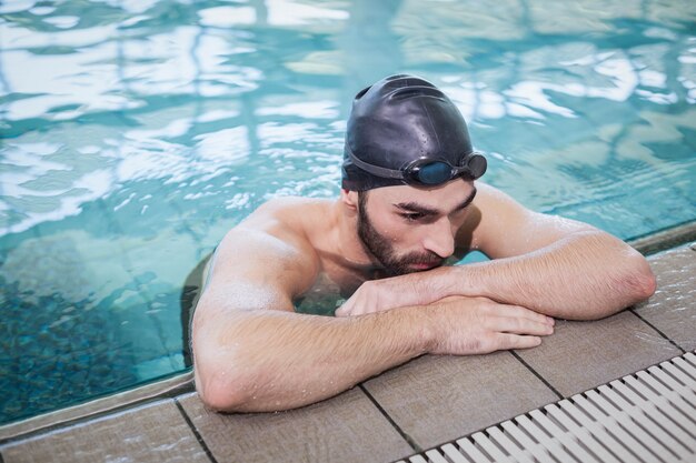 Tired man resting at the edge of the pool