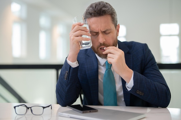 Tired man suffering from headache after computer work exhausted with closed eyes touching head