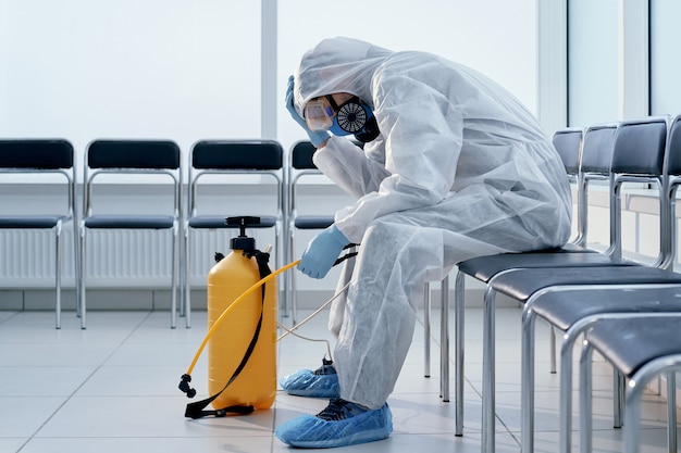 Tired medical orderly in a biohazard suit