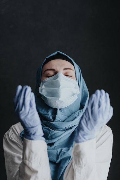 Tired medical worker doctor woman muslim woman in hijab praying after taking a large number of patients due to epidemic of coronavirus