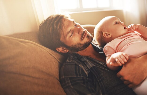 Photo tired morning and father with baby on sofa for bonding care and relax for parenting family home and dad with newborn infant for child development sleeping and affection in living room together