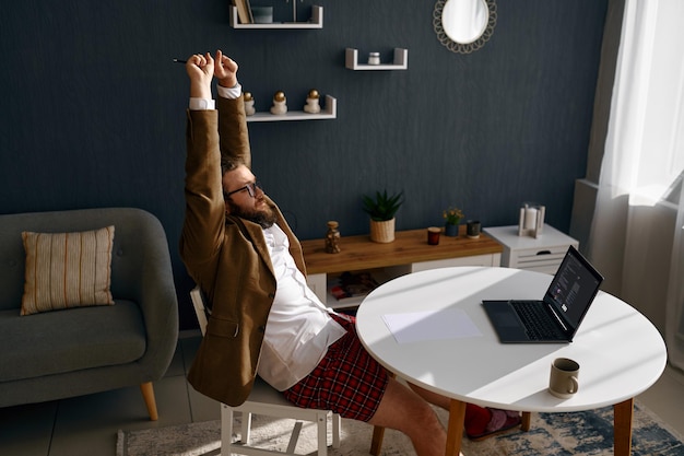 Foto nerd stanco che lavora online dall'ufficio di casa utilizzando un computer portatile