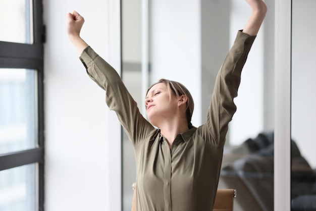 Foto il responsabile dell'ufficio stanco allunga le mani mentre è seduto sul posto di lavoro concetto di superlavoro e