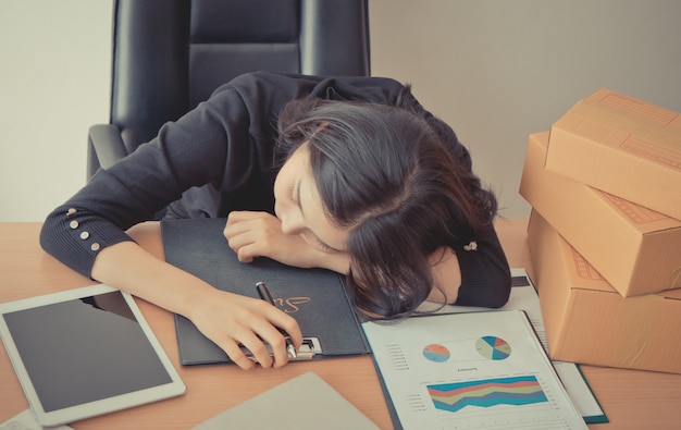 tired office worker is taking a nap on office desk