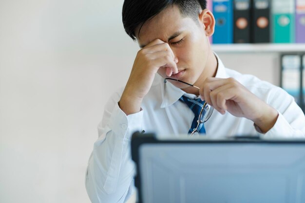 Tired and overworked manager sitting in front of computer and trying to concentrate his eyes are dry