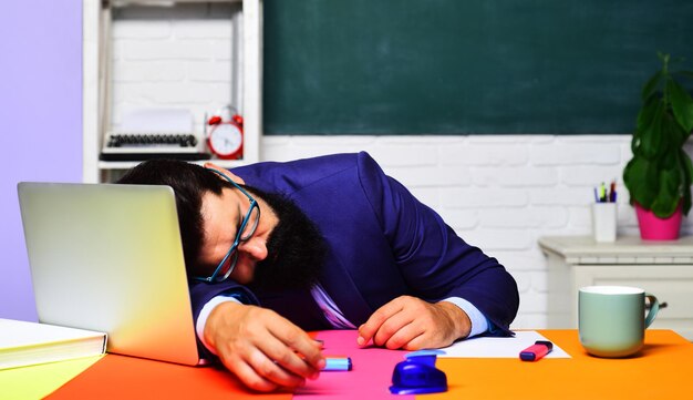 Уставший перегруженный работой учитель спит за столом, знания, образование и концепция обучения спящего мужчины