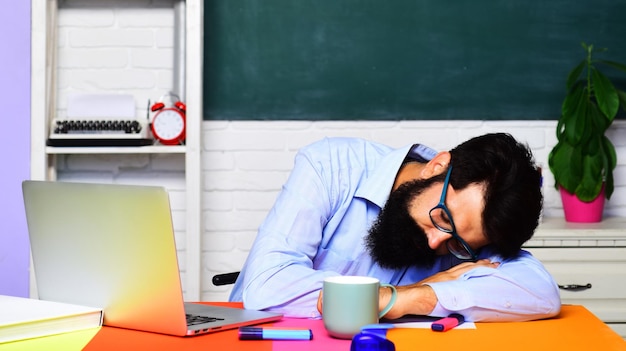 Photo tired overworked teacher sleeping on desk in classroom school job world teachers day back to school