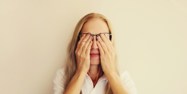 Tired overworked woman employee rubbing her eyes suffering from eye strain dry eye syndrome