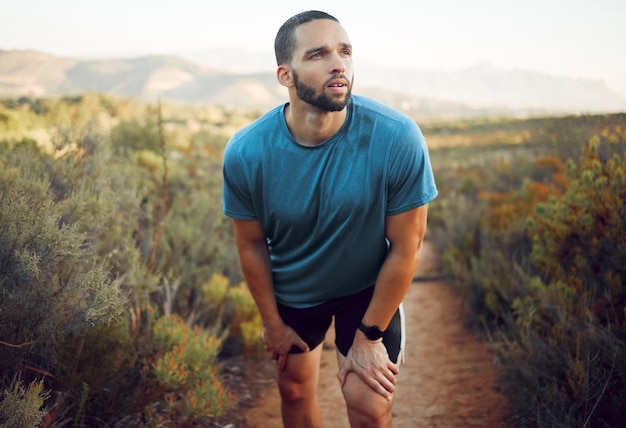 Foto corridore stanco che corre sul sentiero del parco naturale esercizio di allenamento fitness e salute cardio per una maratona estiva atleta sportivo corre allenamento riposo su strada naturale e treno per gare sportive