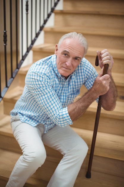 Утомленный старший человек сидя на лестнице