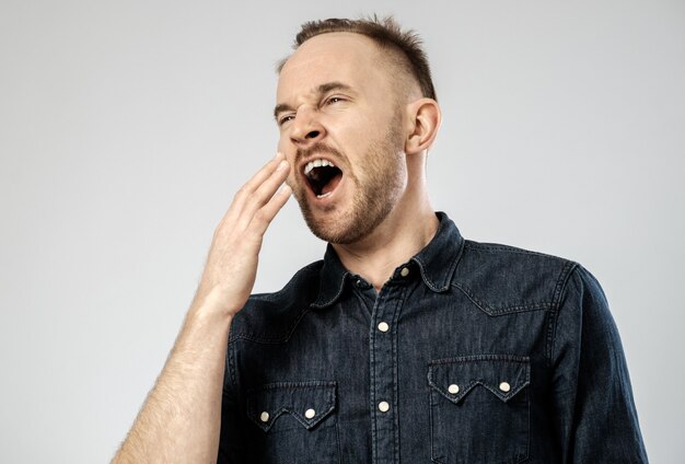 Tired sleepy young man yawning