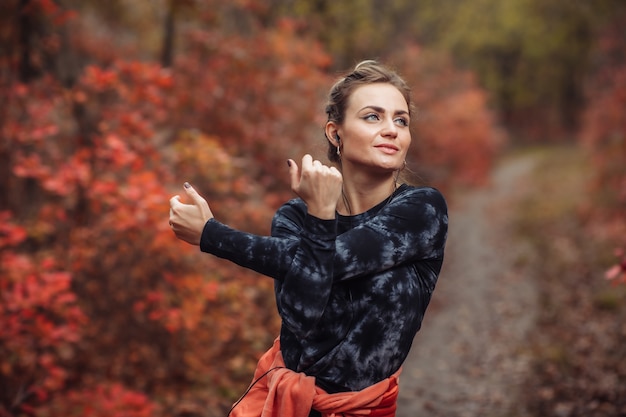 Tired sport woman in sportswear in the autumn forest