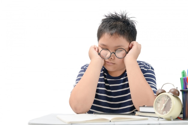 Tired student boy with glasses sleeping on the books 