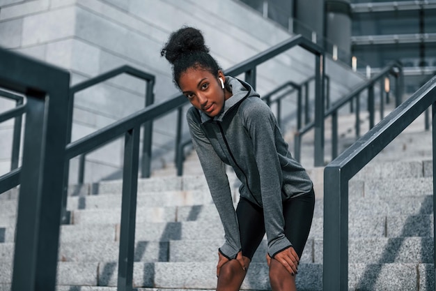 Tired takes break Young african american woman in sportive clothes have workout outdoors at daytime