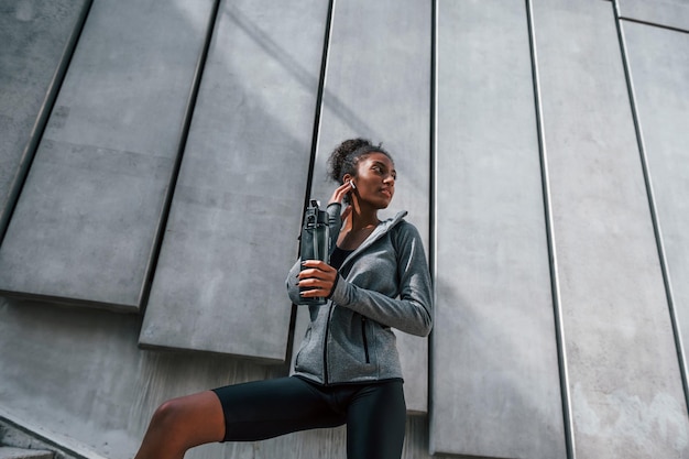 Foto la stanca si prende una pausa la giovane donna afroamericana in abiti sportivi si allena all'aperto durante il giorno