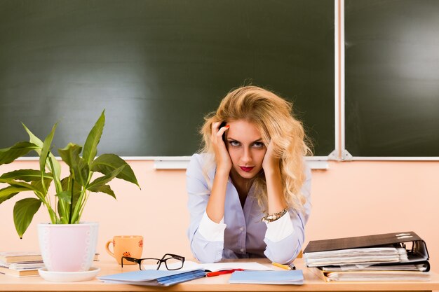 Photo tired teacher checking the tests. back to school concept.