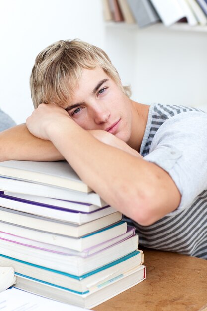 Tired teeenager sleeping on books