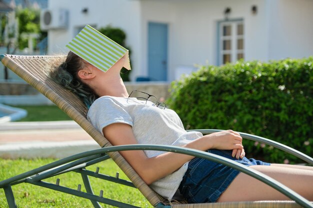Девушка с книжкой лежит на лежаке