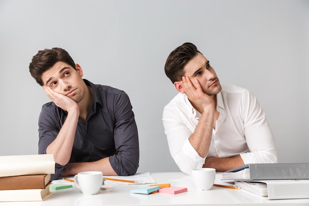 Tired two young business men colleagues