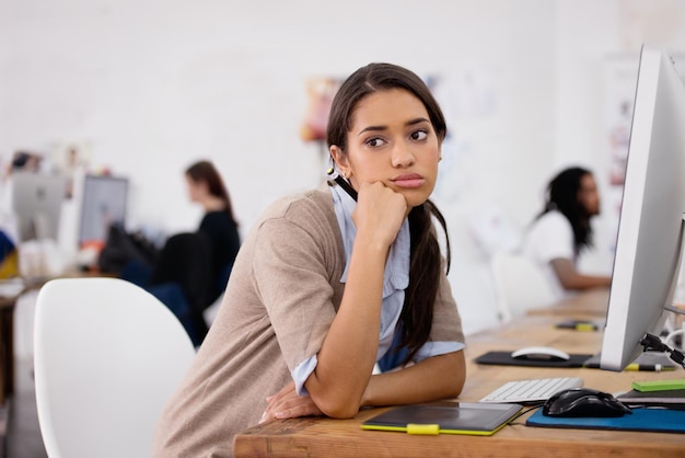 Tired woman and bored in coworking space with computer for planning schedule and ideas for job Businesswoman thinking and technology in office with depression exhausted or burnout at desk