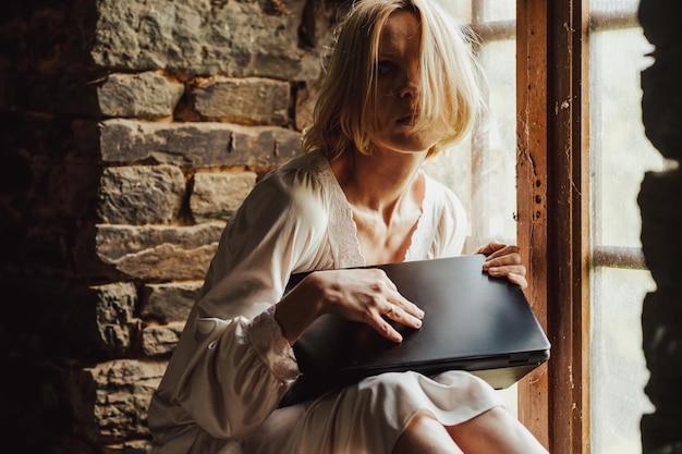 Tired woman buries her laptop End of work time to relax Creative crisis