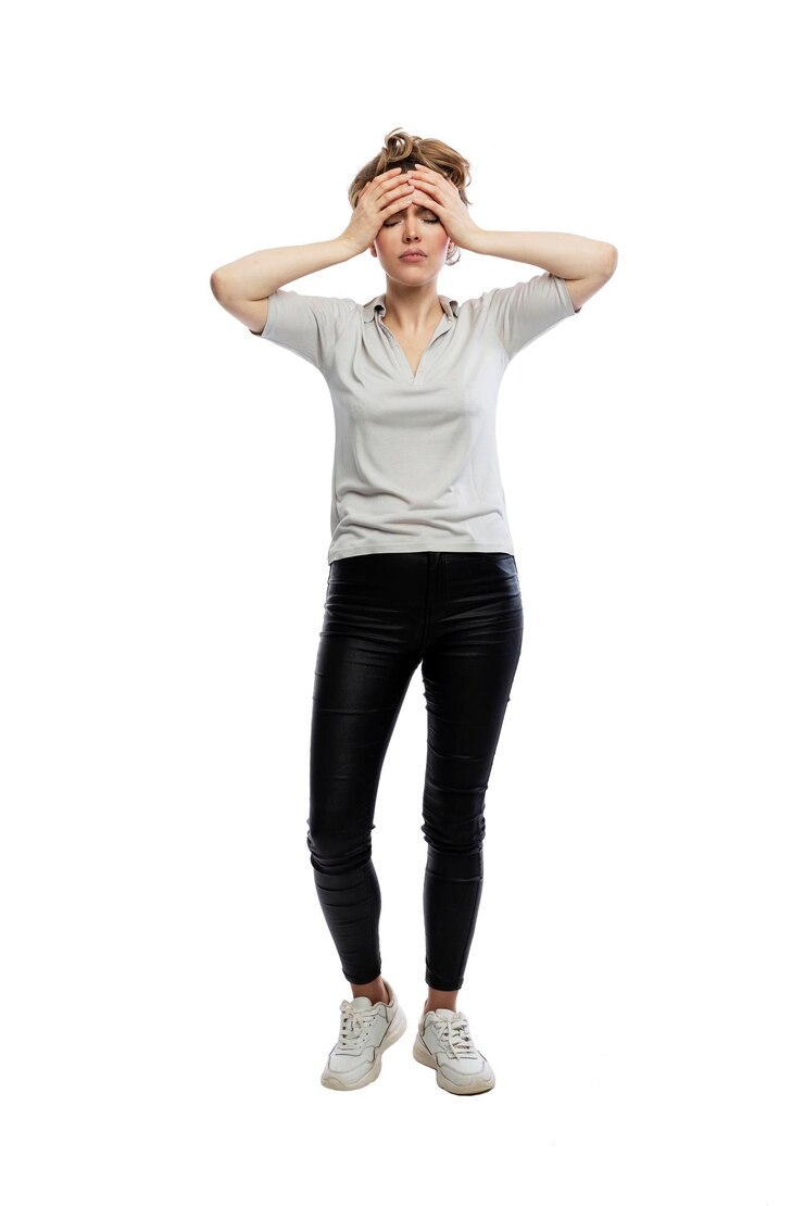 Photo tired woman holding her head. young beautiful blonde in black leggings, gray tank top and white sneakers. pain, depression and stress. isolated on white background. full height. vertical.
