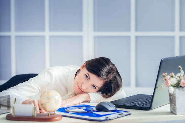 Tired woman at the office desk in the evening