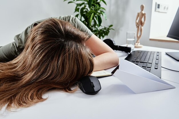 Tired woman sleeps while remotely working at home overwork burnout