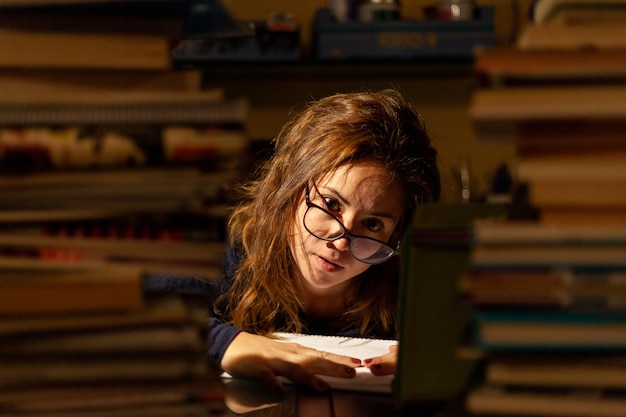 tired woman studying between many books