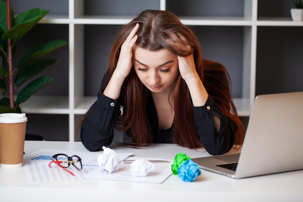 Tired woman working at the computer in the office